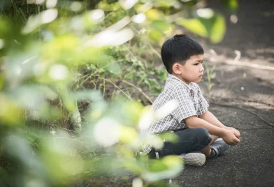 cute-little-boy-sitting-ground-summer-park_11zon