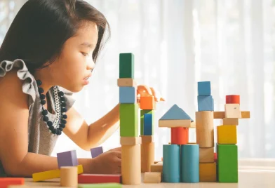 little-girl-playing-with-construction-toy-blocks-building-tower_11zon