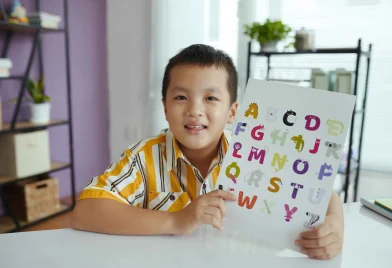 portrait-of-smiling-boy-showing-colorful-alphabet-2024-08-28-21-10-50-utc_11zon